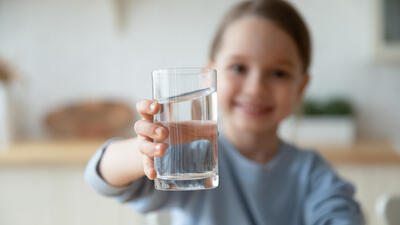 Girl holds clear glass of water