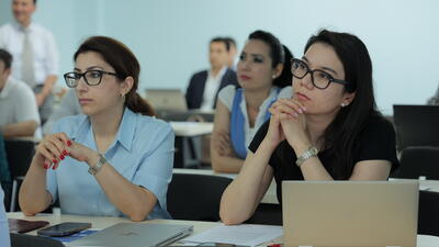 Two Uzbek women listen attentively at workshop on WTO rules on intellectual property