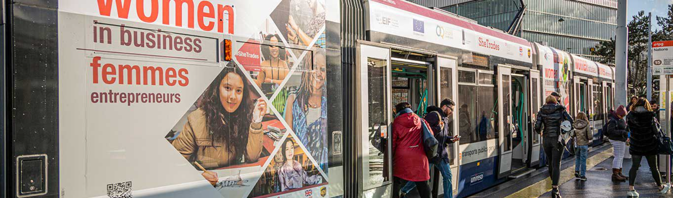 tram with campaign branding at the Geneva nations stop, some people getting in or out of tram.